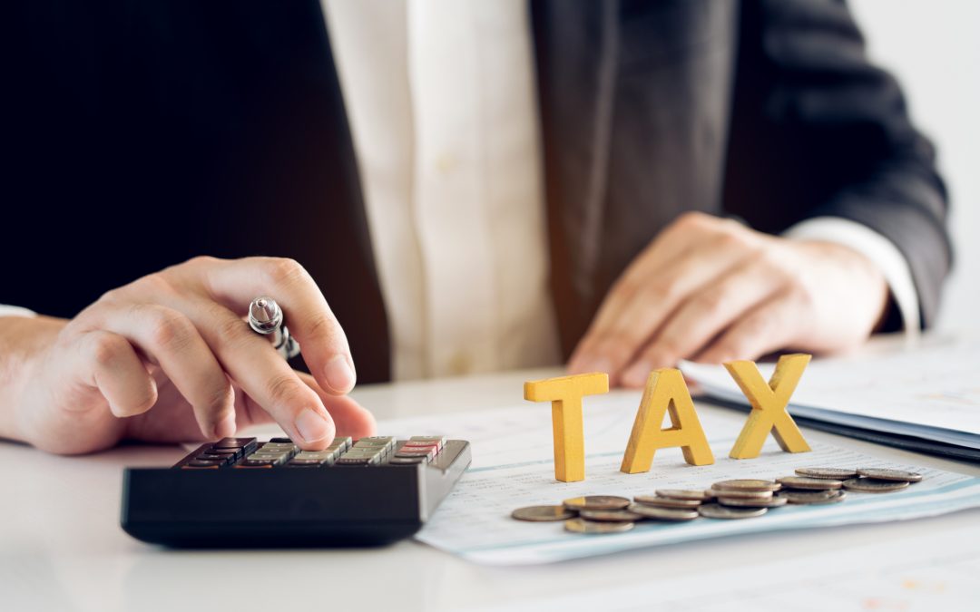 Businessman's hands calculating numbers at a calculator. Tax deduction planning concept.